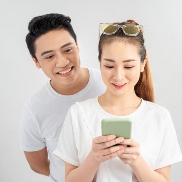 Hombre espiando teléfono de una mujer para saber con quién comparte más chats y contenido en WhatsApp.- Blog Hola Telcel