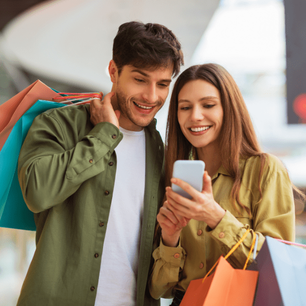 Pareja de compras haciendo uso de la app Claro Pay para pagar en servicios.