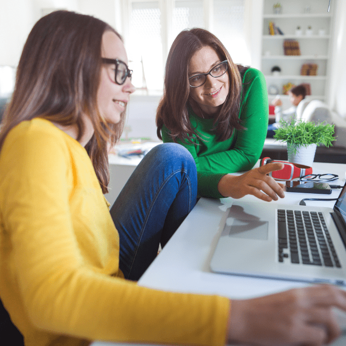Mamá e hija haciendo tarea en computadora. 